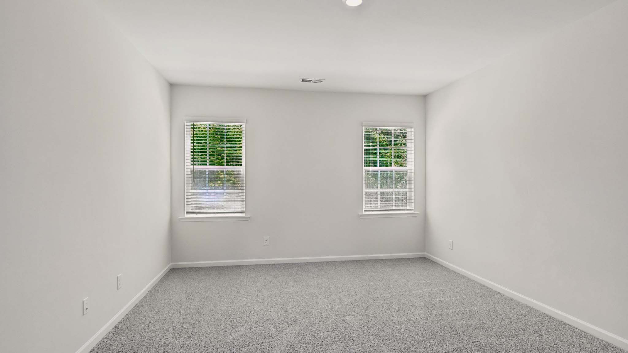 Carpeted bedroom with two windows