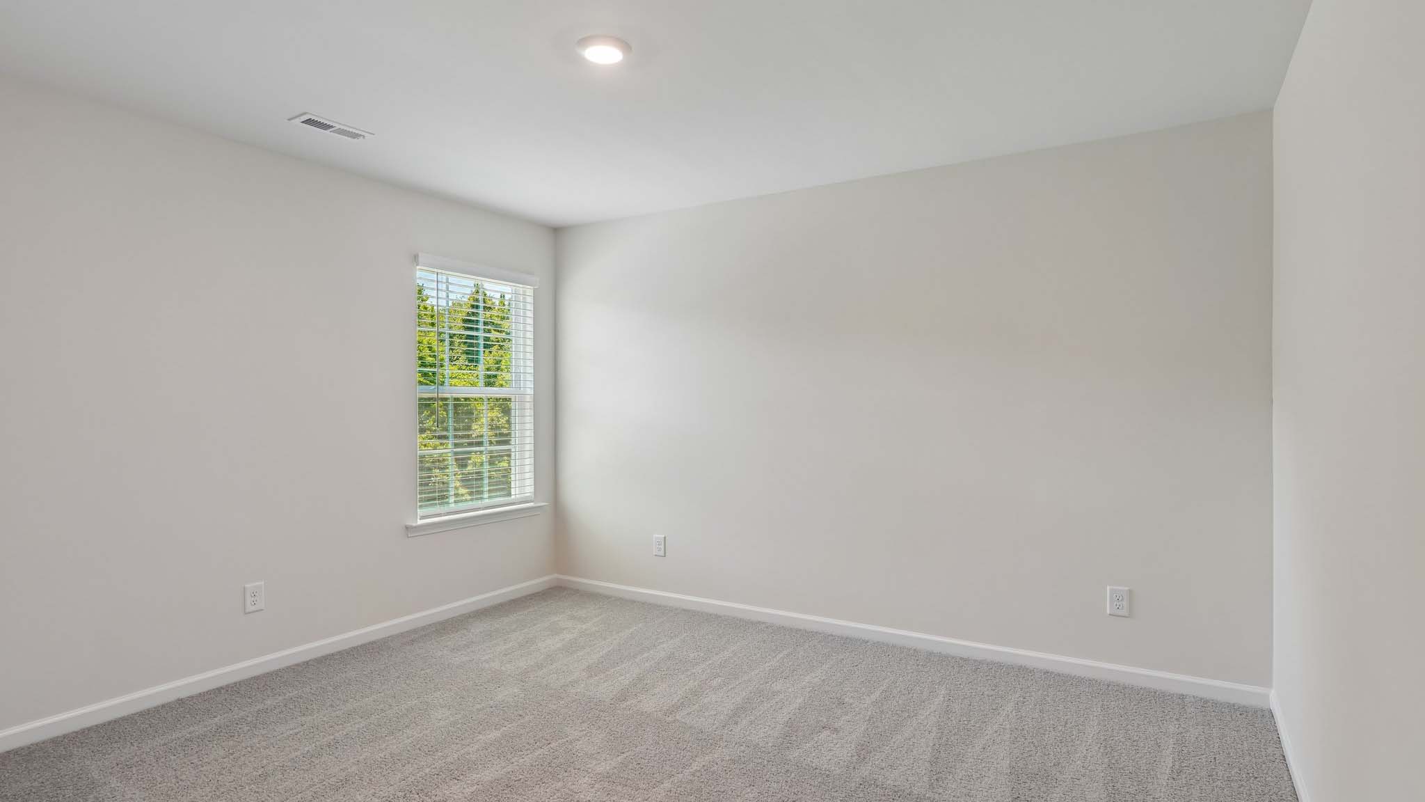 Carpeted bedroom with two windows