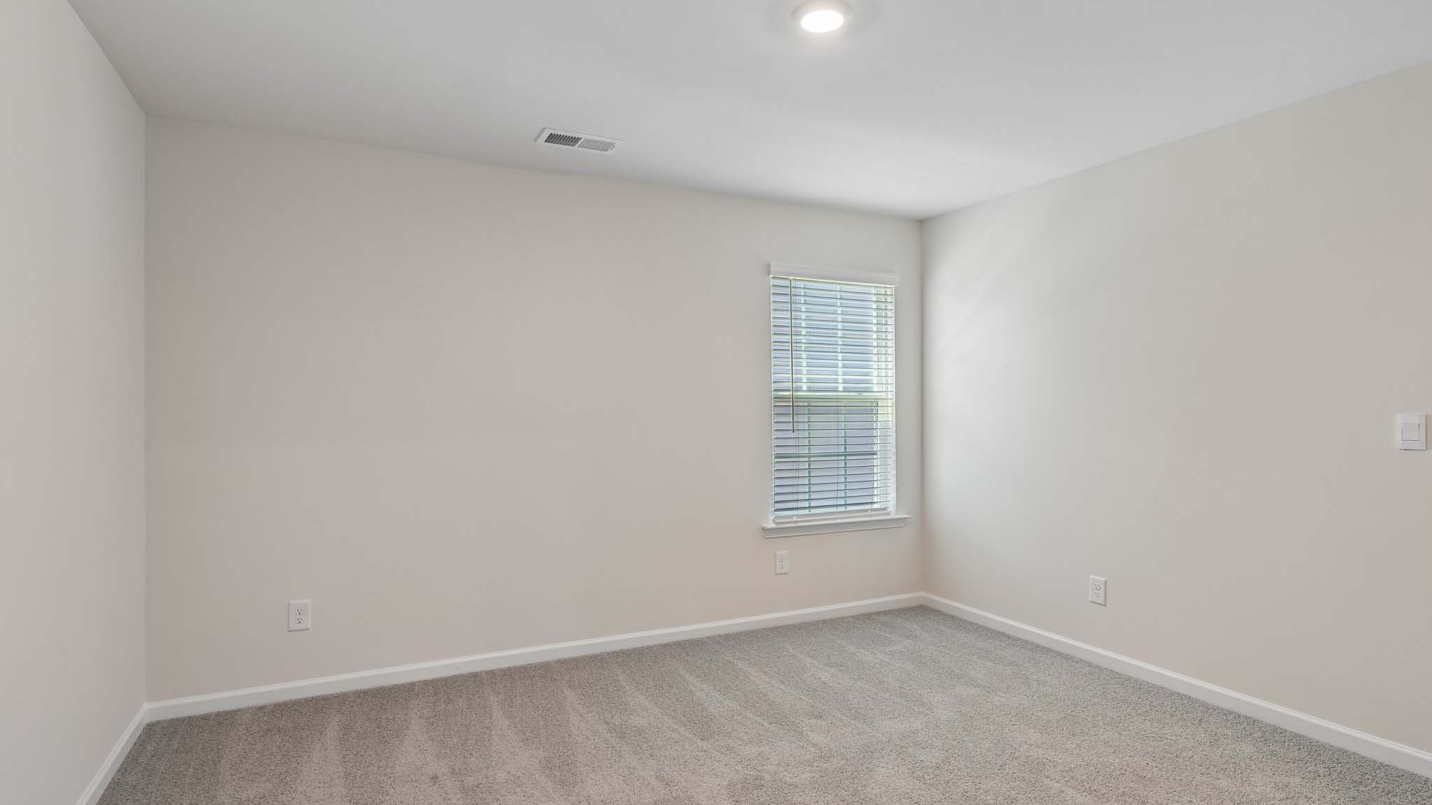Carpeted bedroom with two windows