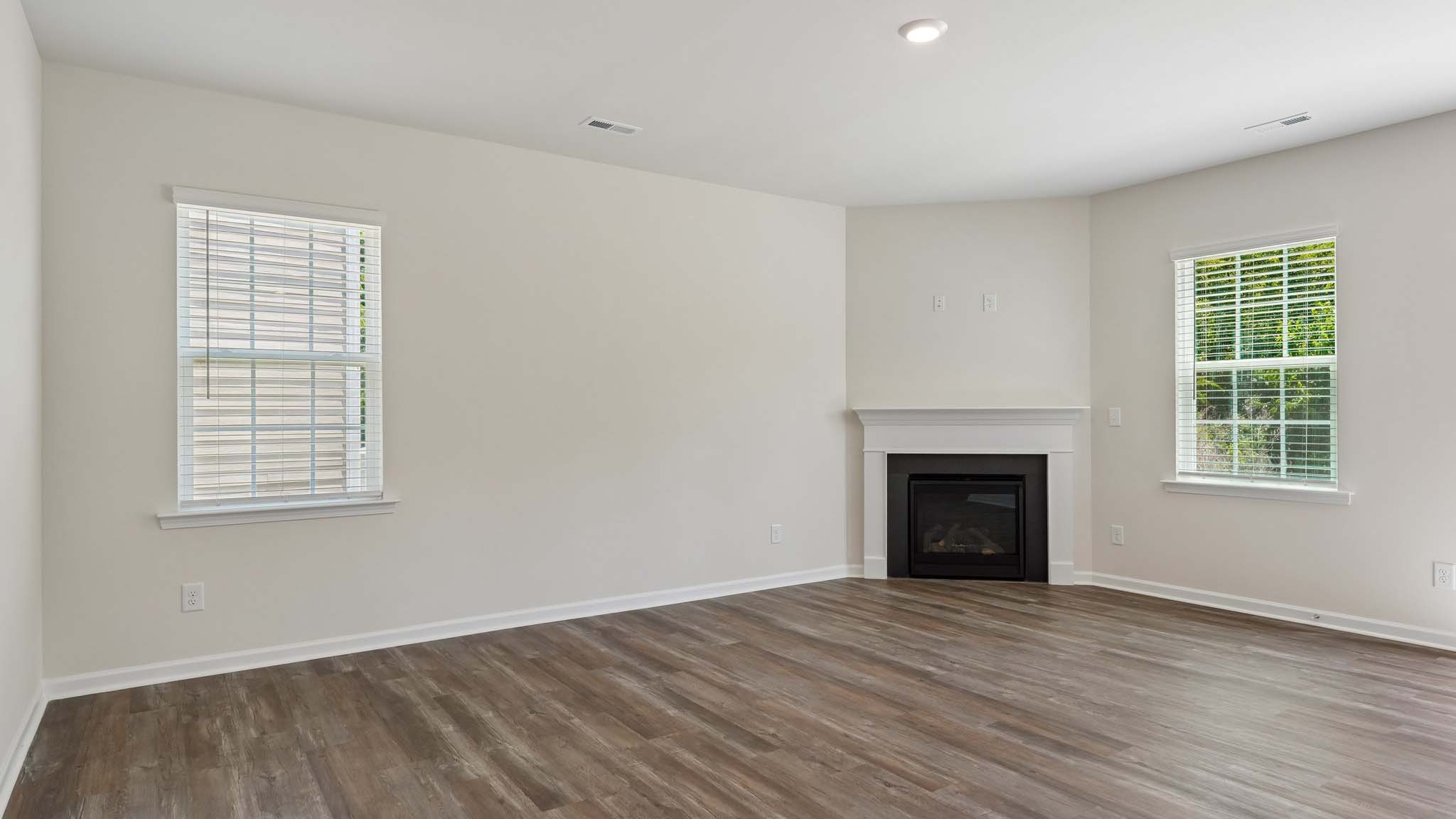 Open family room with fireplace and windows on either side