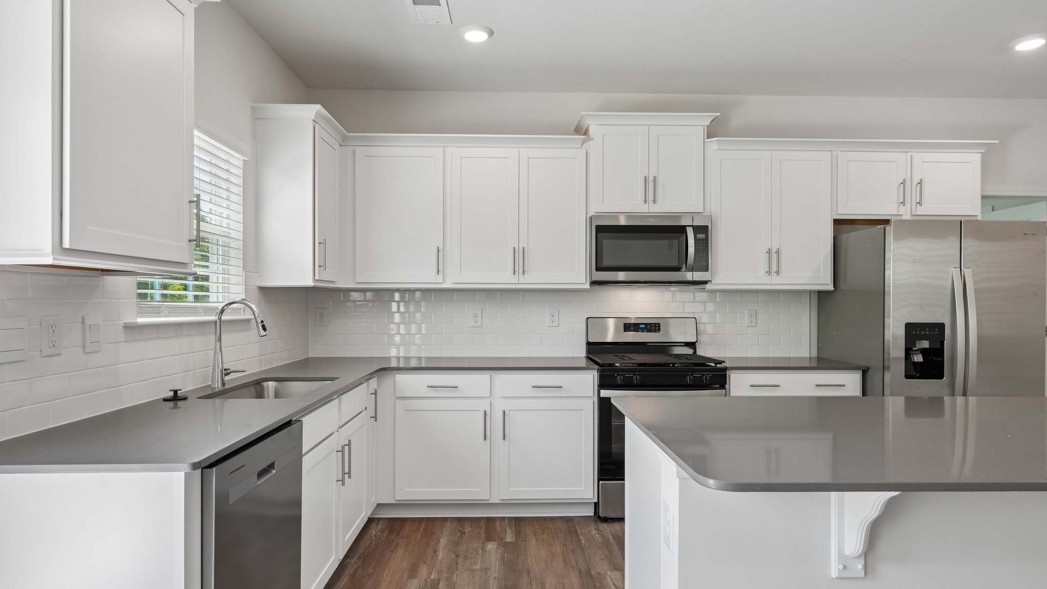 Kitchen and island with white counters and cabinets