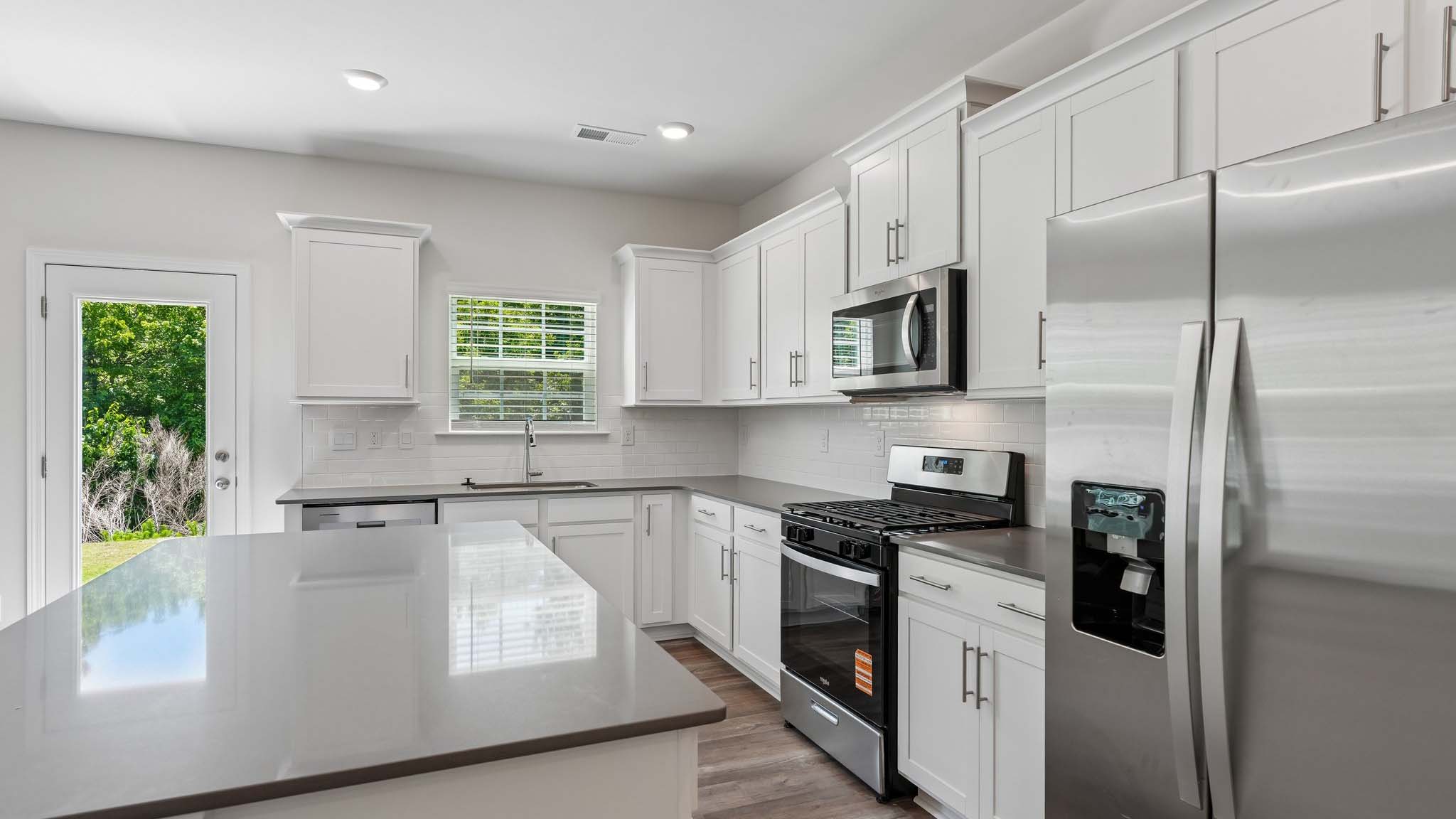 Kitchen and island with white counters and cabinets