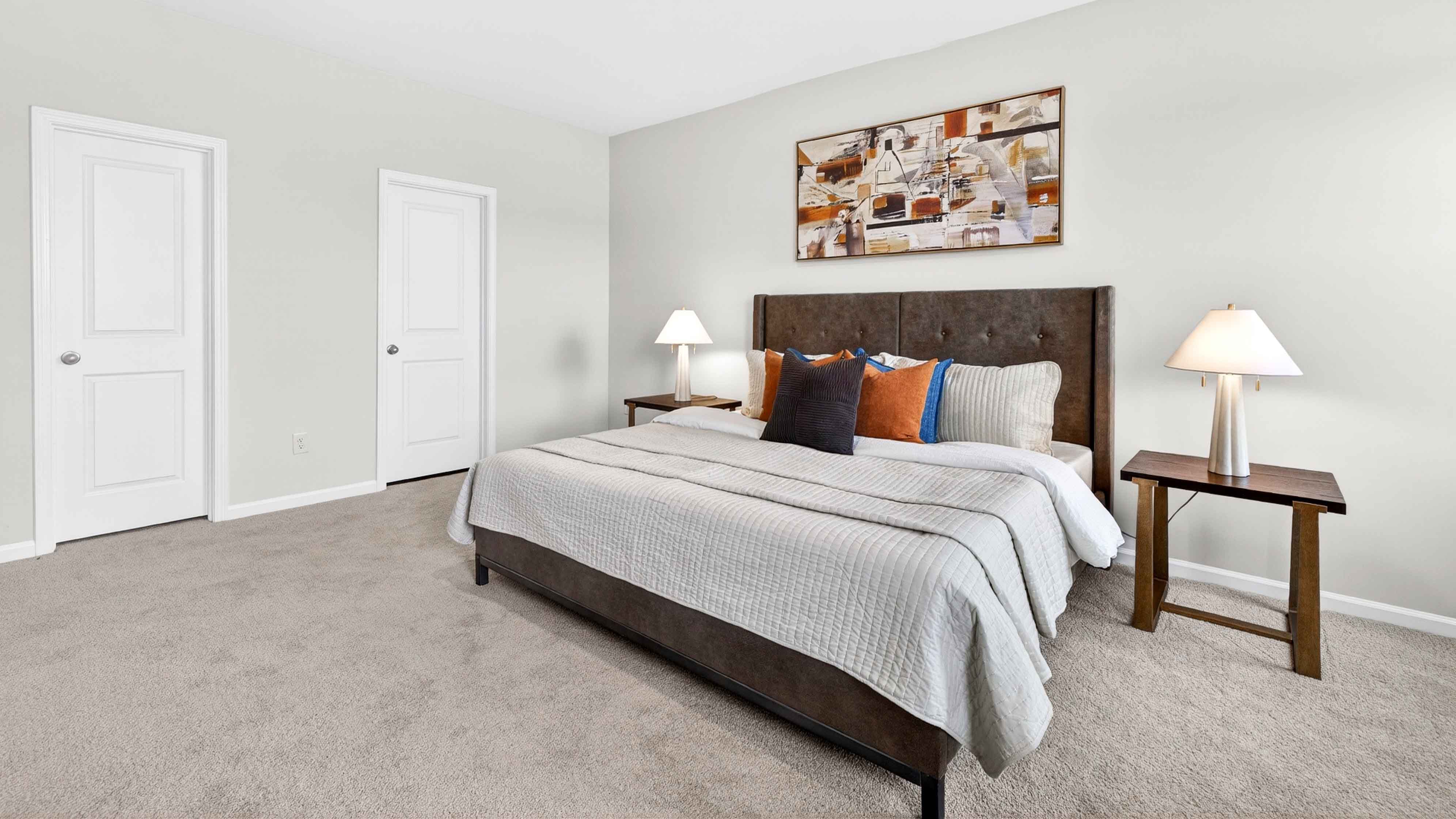 Carpeted primary bedroom with two small windows