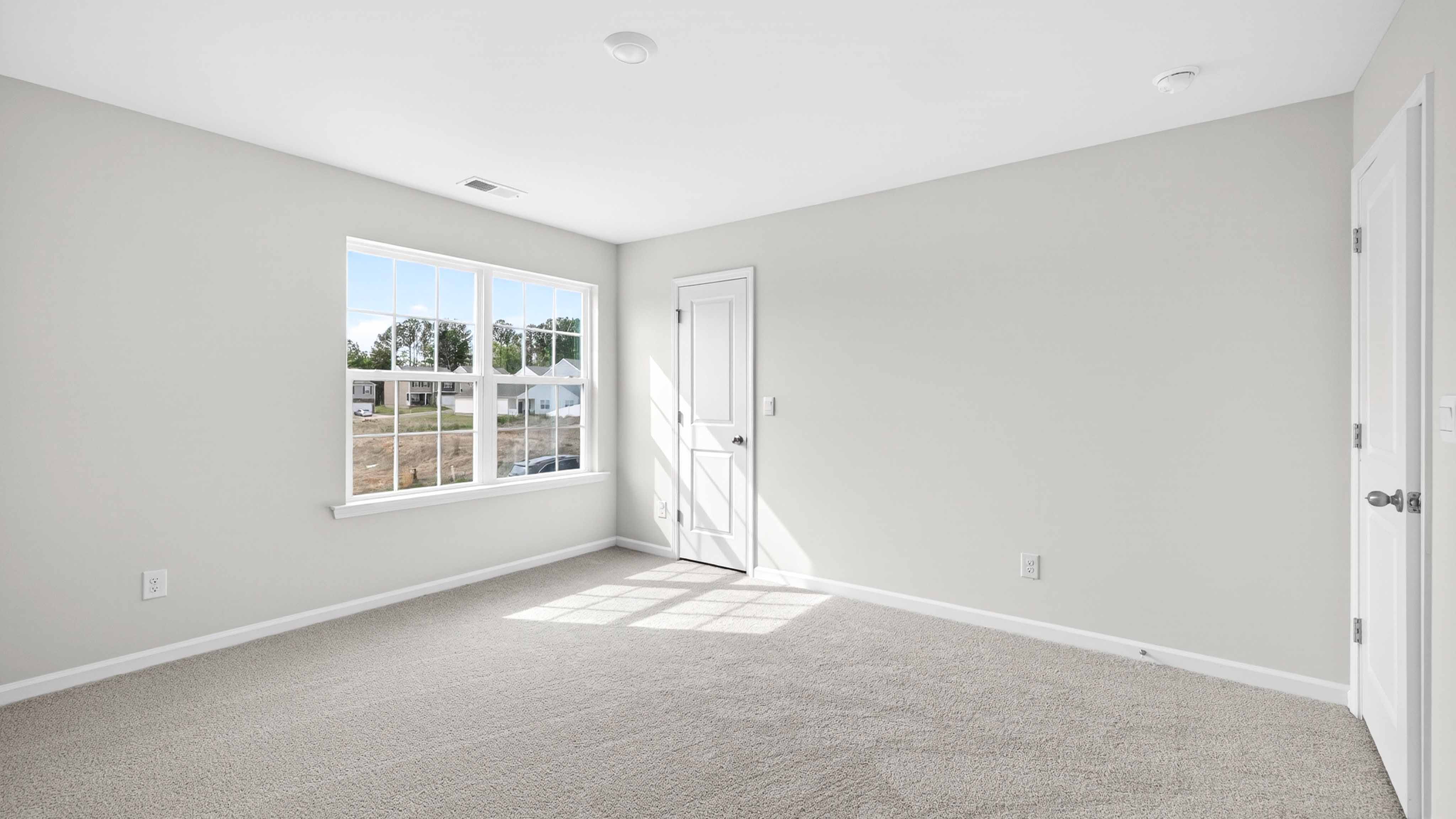Carpeted bedroom with windows