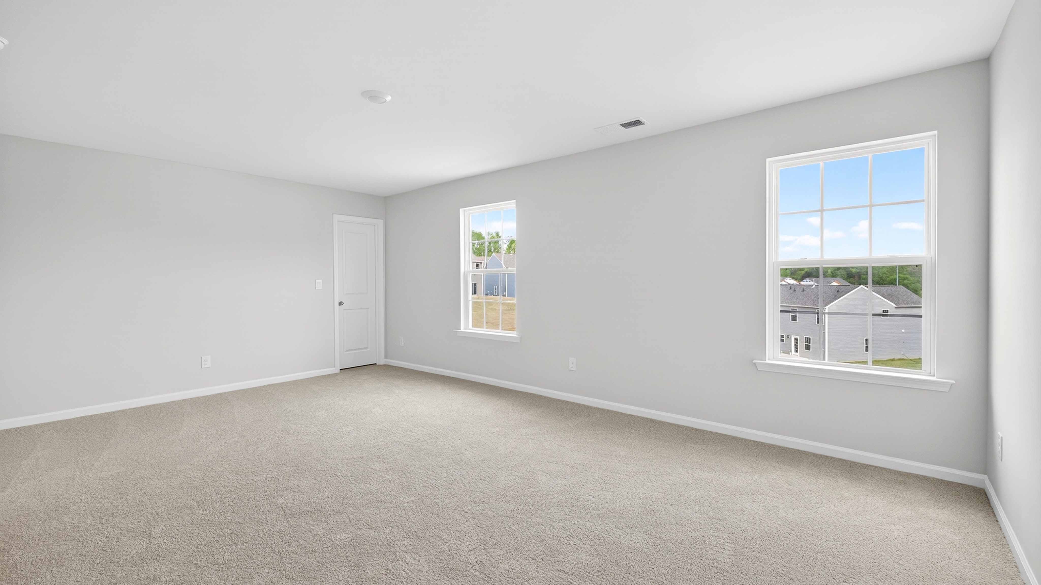 Carpeted bedroom with windows