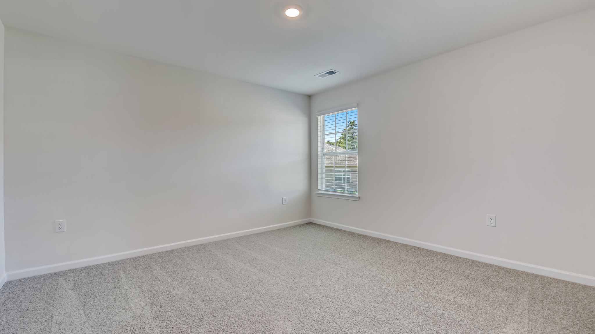 Carpeted bedroom with large window