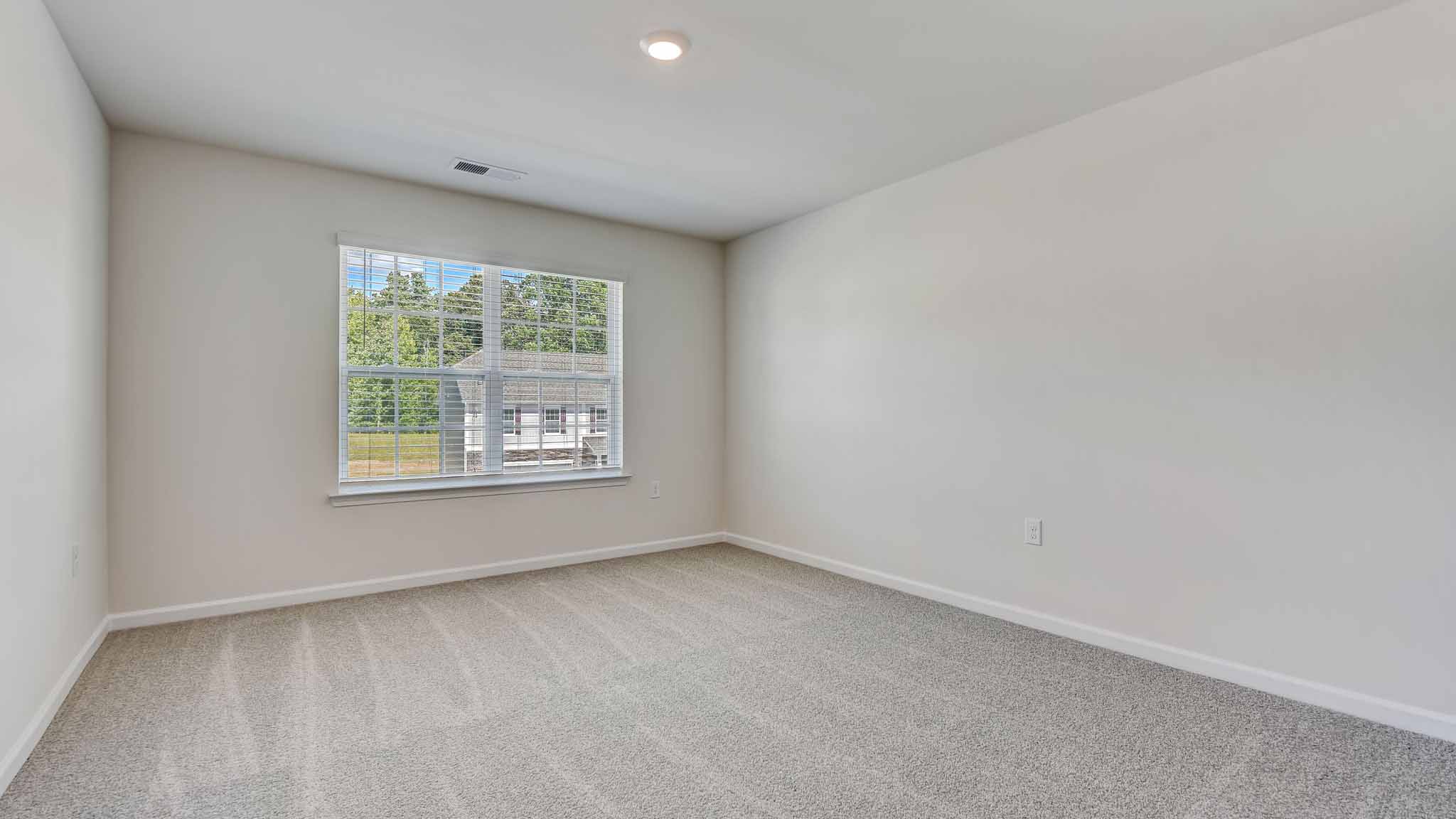 Carpeted bedroom with large window
