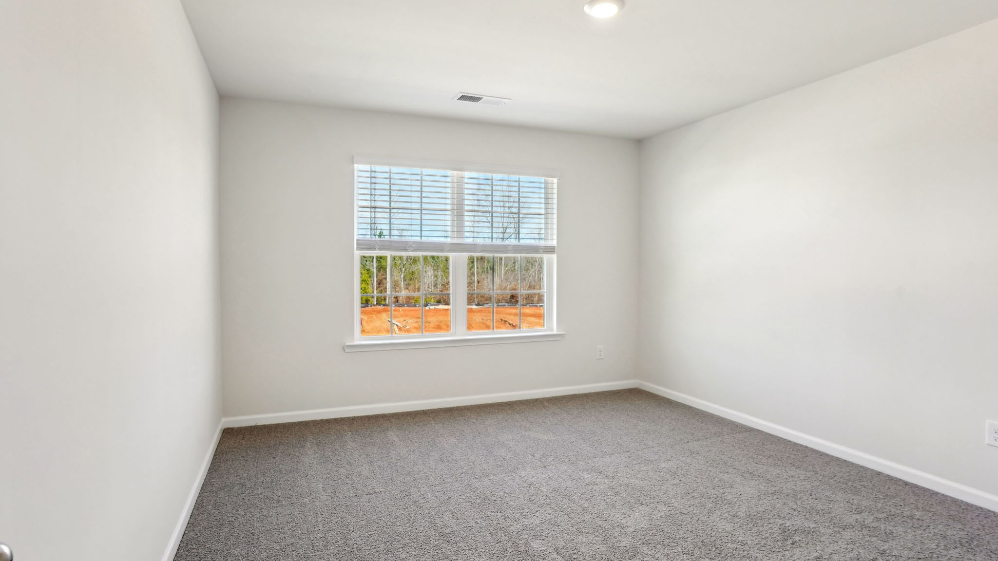 Carpeted bedroom with large window