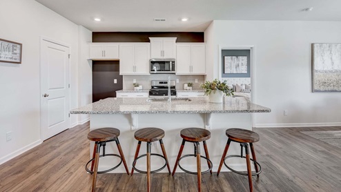 kitchen and island with white cabinets and counters, and stainless steel appliances