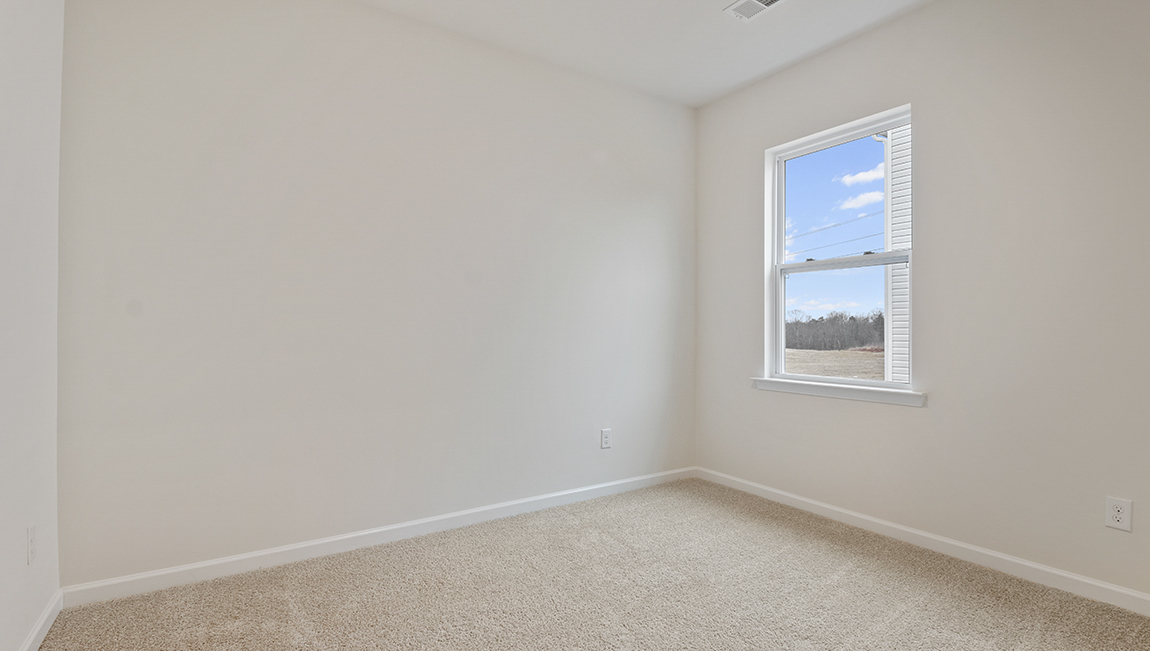 Carpeted bedroom with small window