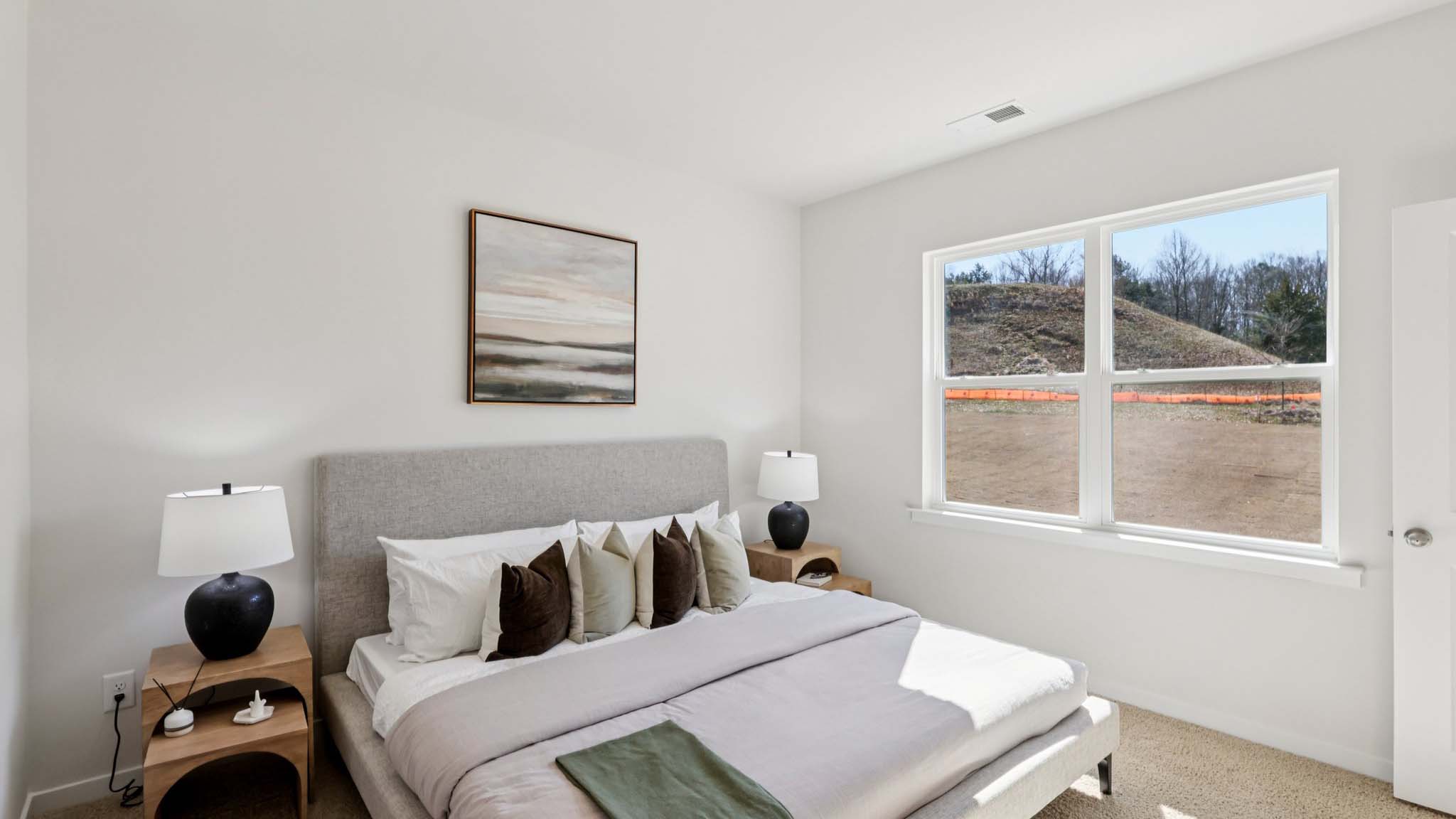 Primary carpeted bedroom with large window