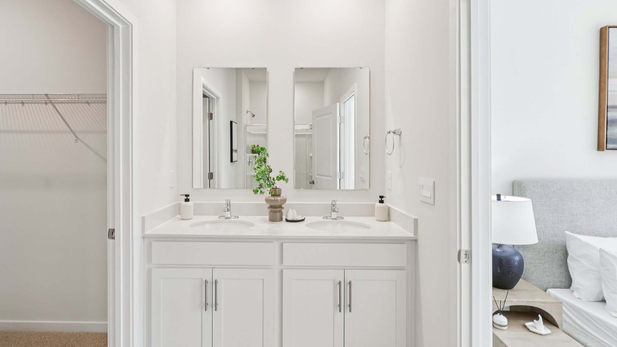 Primary bathroom with white counters and glass door shower