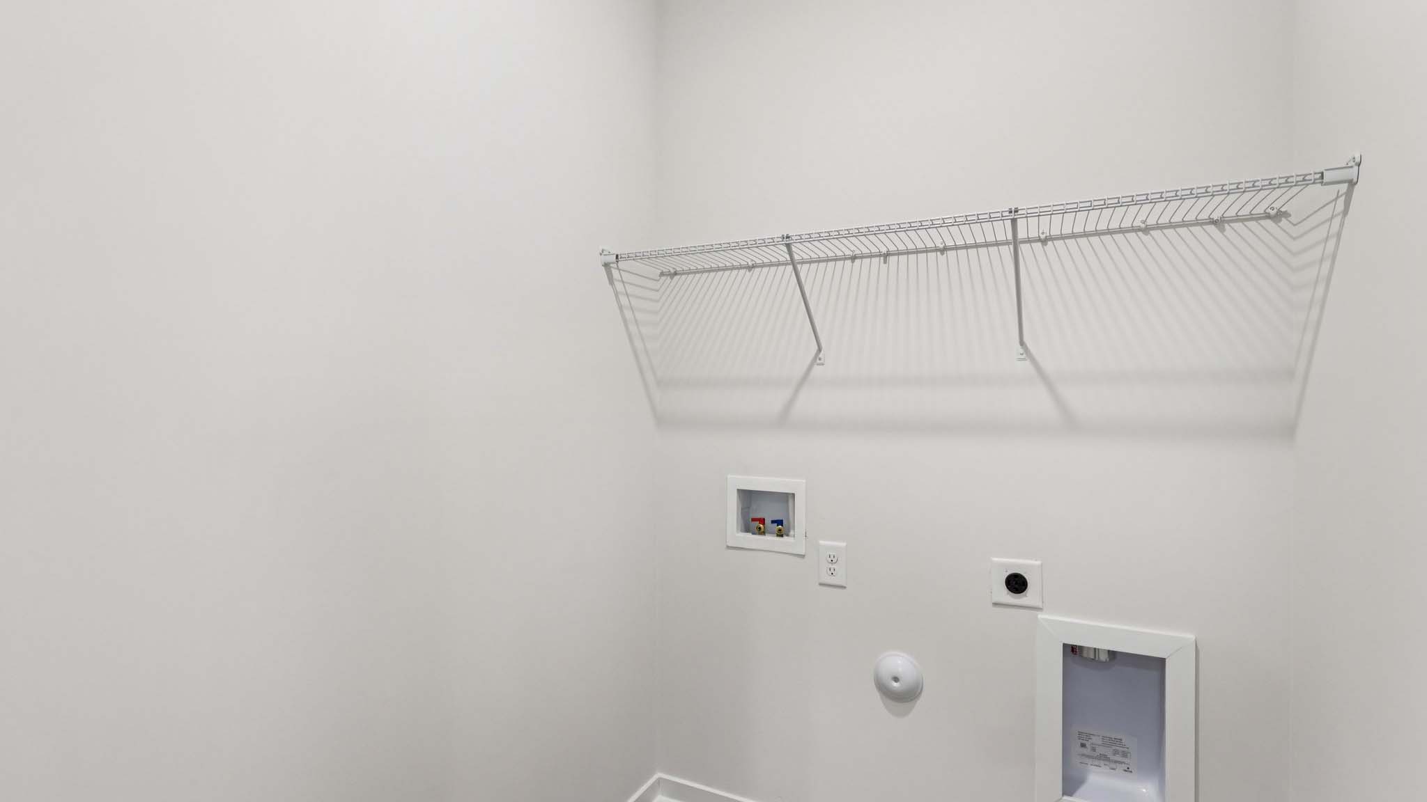 Laundry room with built in racks above the machines