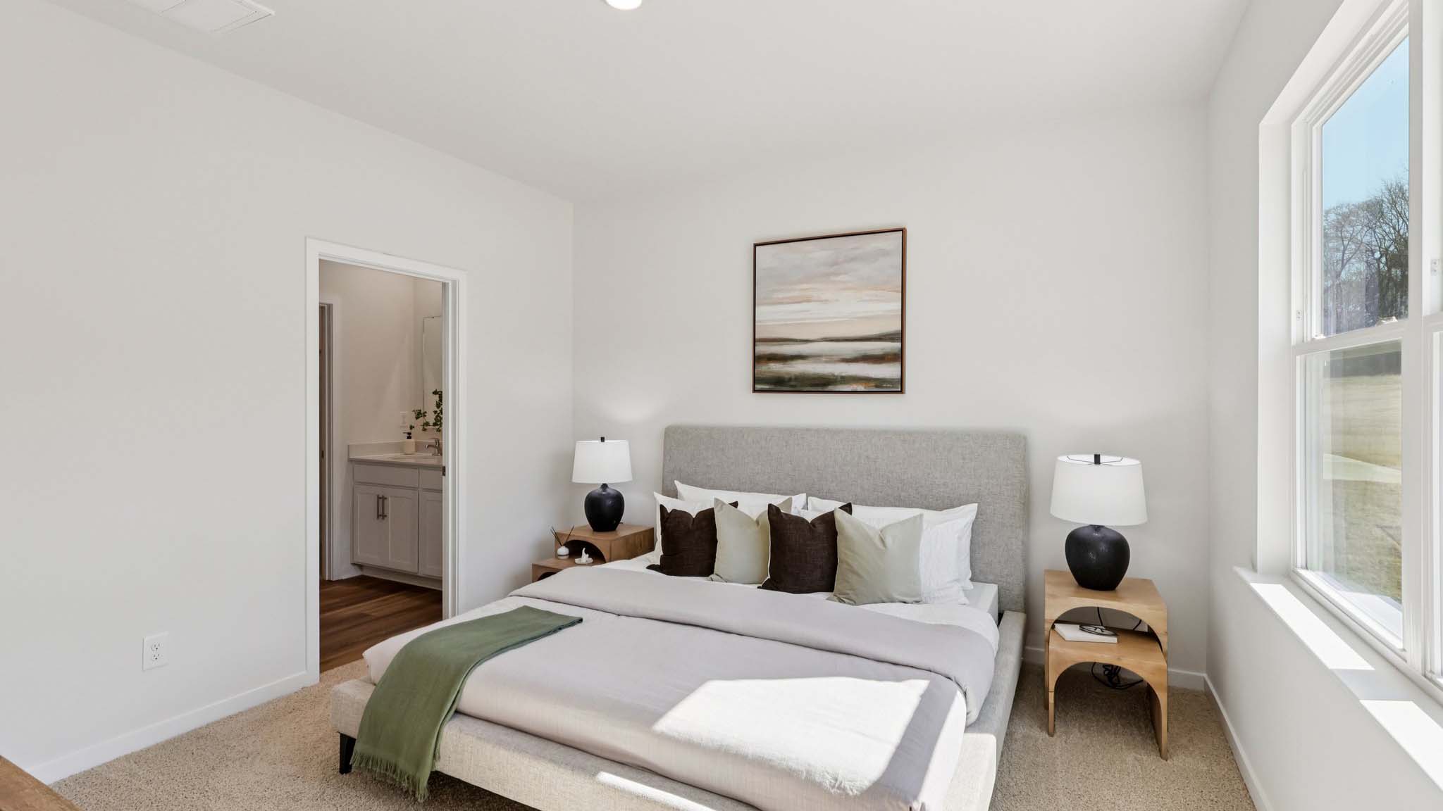 Primary carpeted bedroom with large window