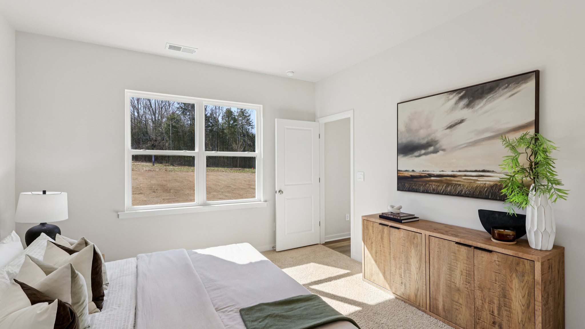 Primary carpeted bedroom with large window