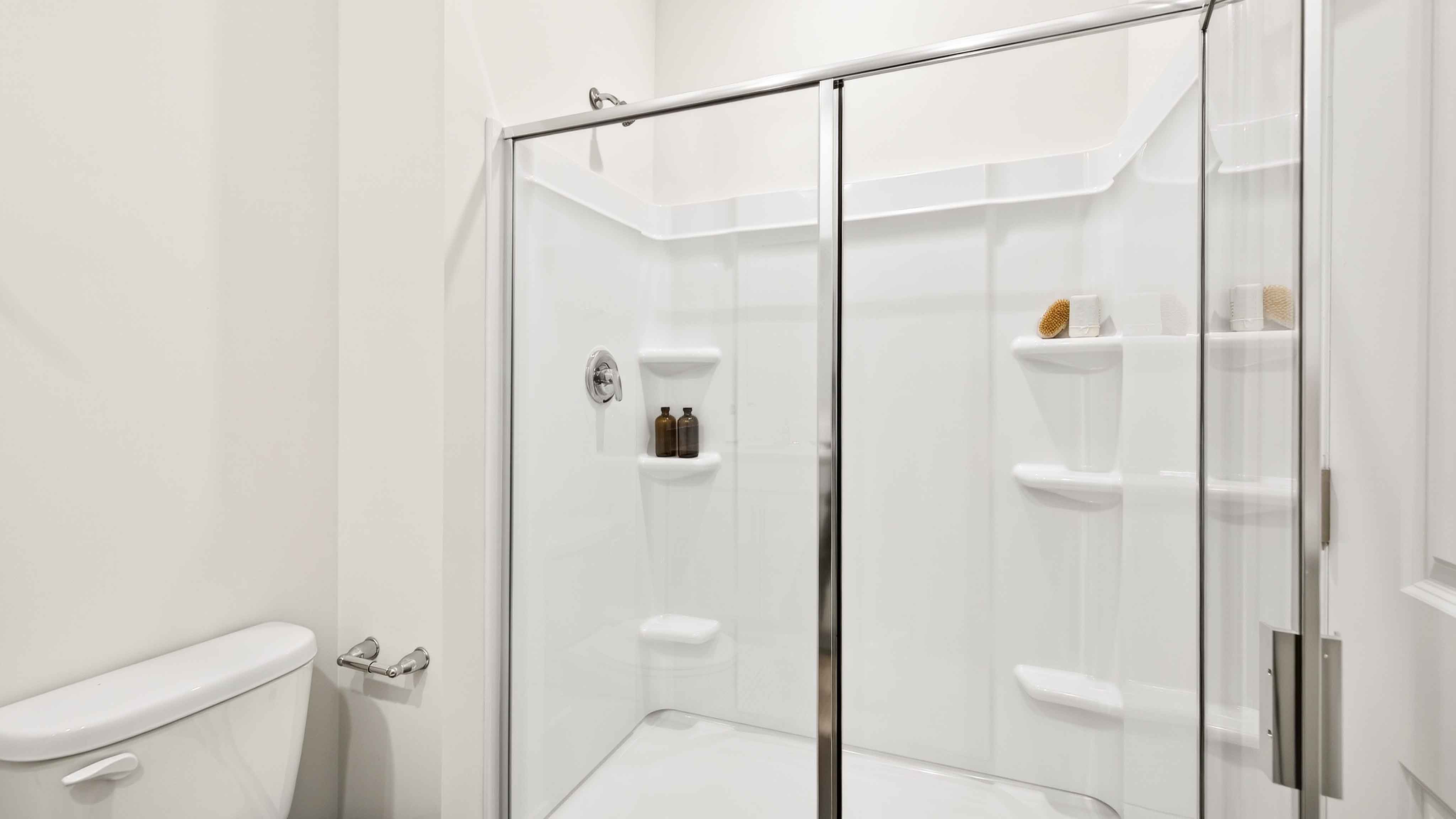 Primary bathroom with white cabinets and standing glass shower