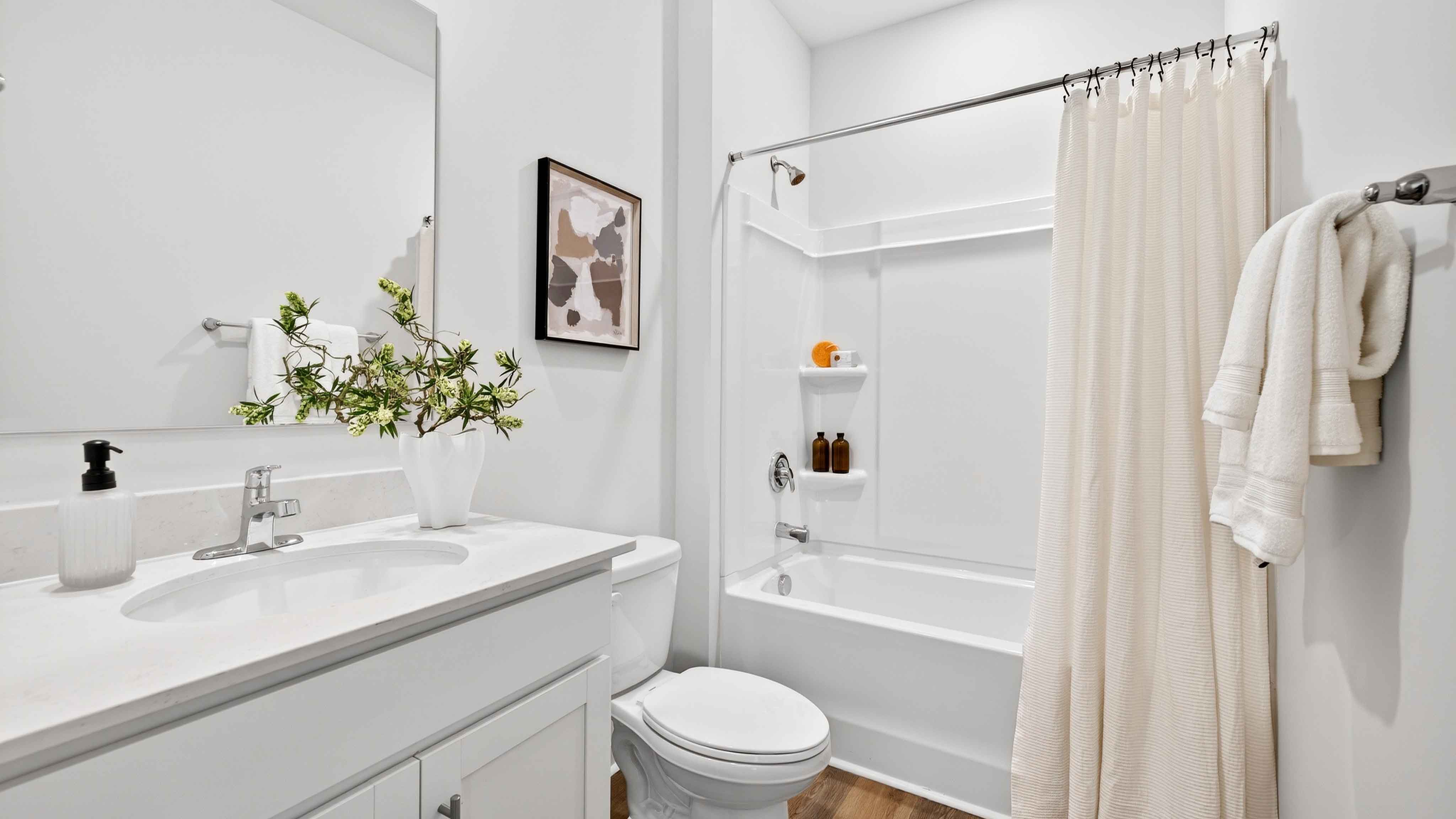 Bathroom with bathtub, white counters and cabinets