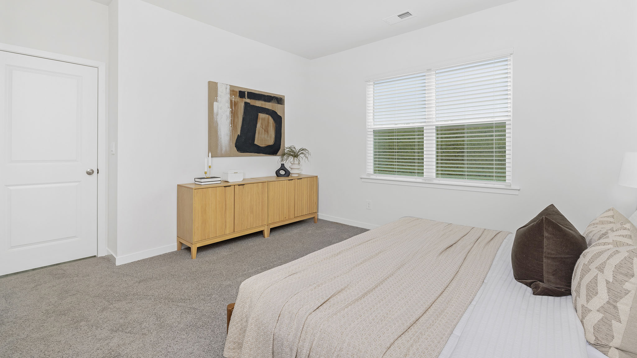 Primary carpeted bedroom with large window