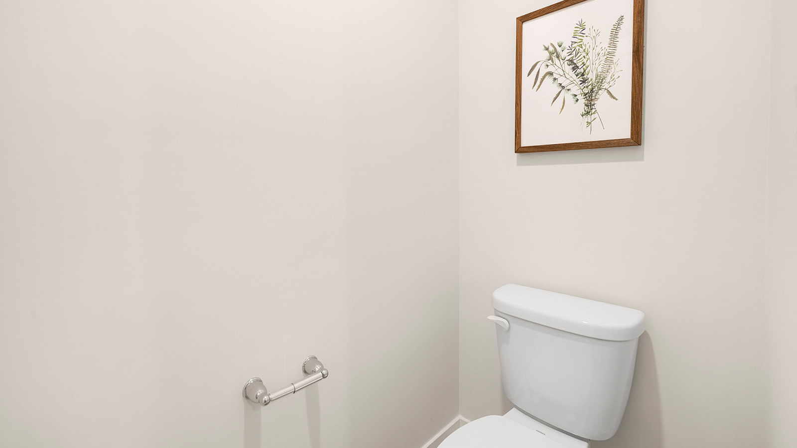 Primary bathroom with double sinks, white cabinets and glass door shower
