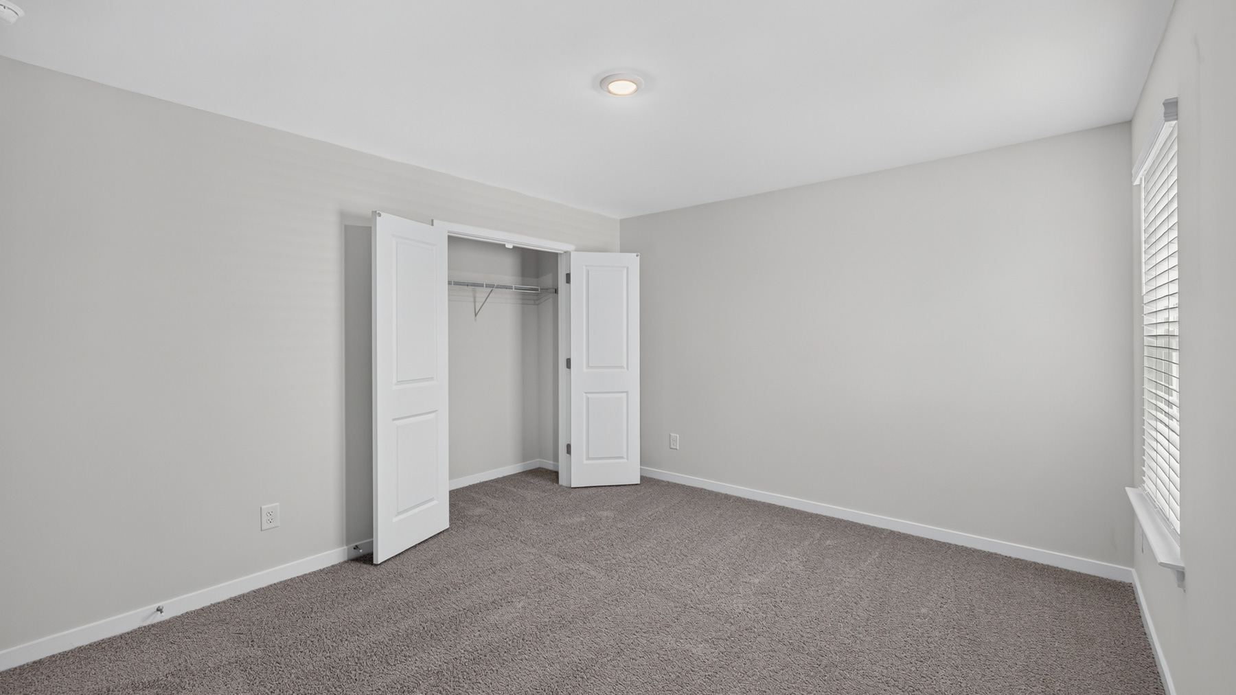 Carpeted bedroom with large window