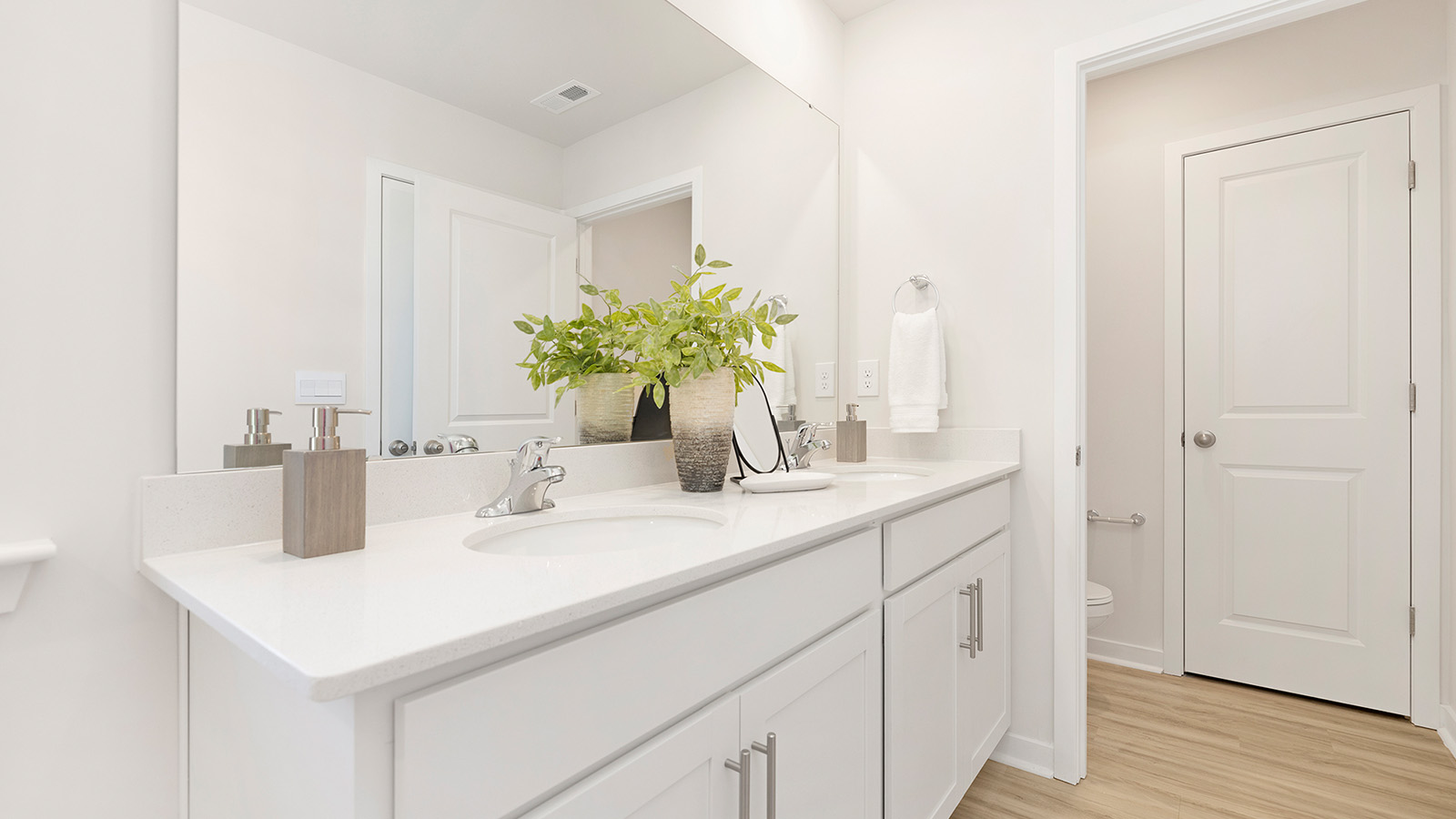 Primary bathroom with white cabinets and standing glass shower