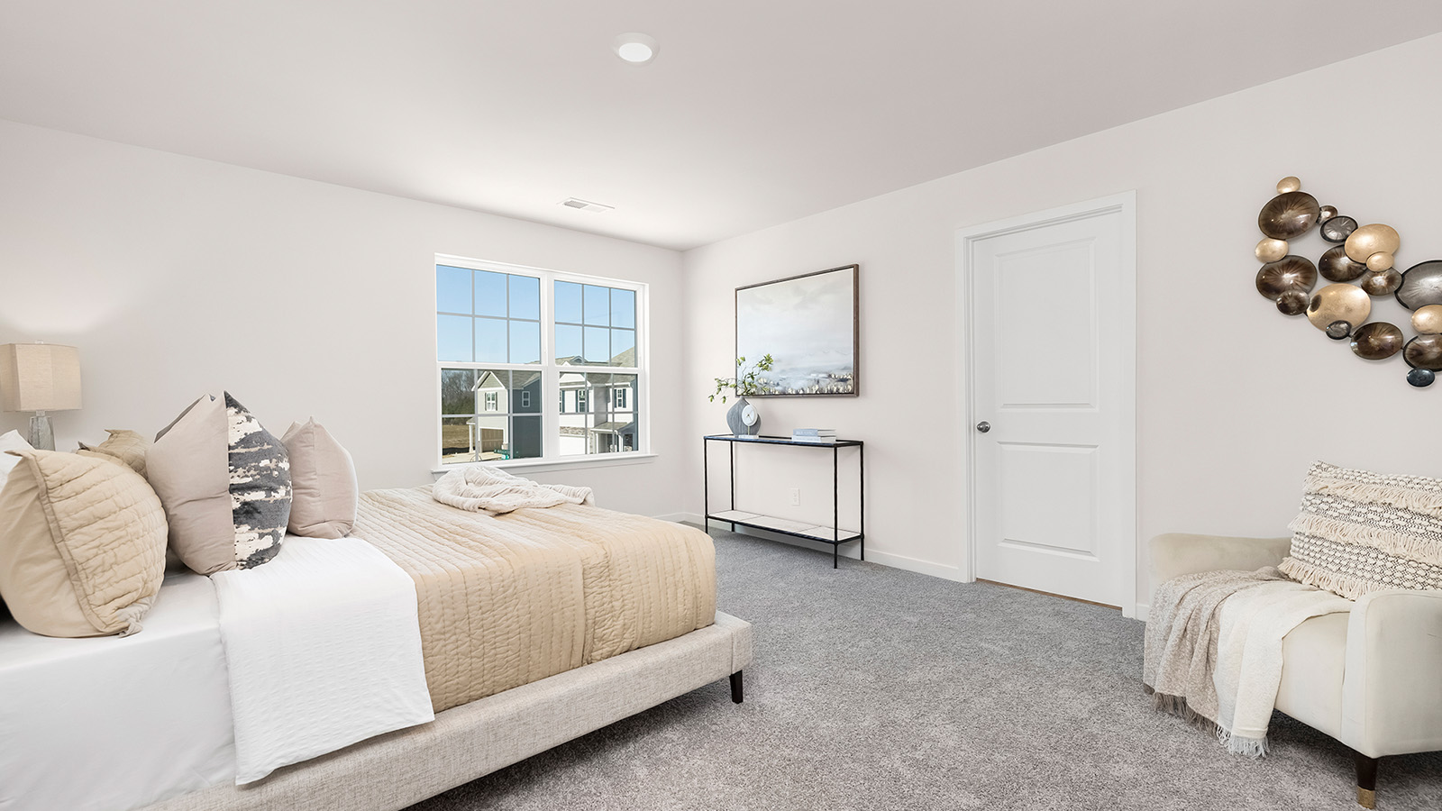 Carpeted primary bedroom with large windows
