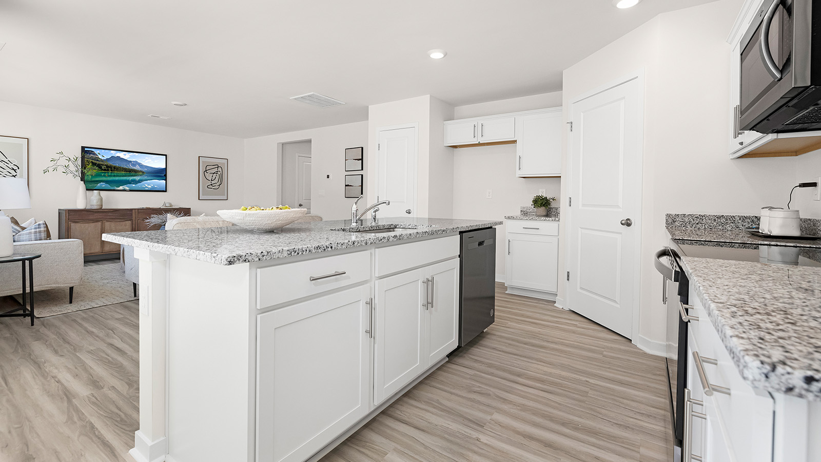 Kitchen and island with white cabinets and stainless steel appliances