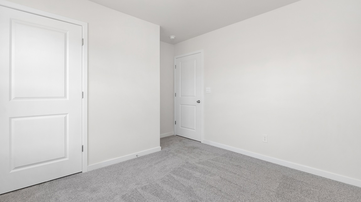 Carpeted bedroom with large windows