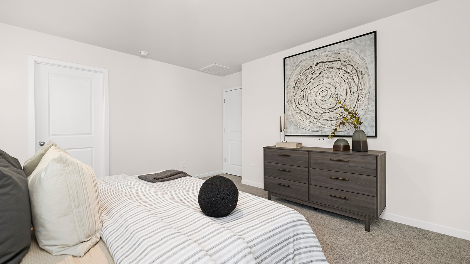 Primary bedroom carpeted with two large windows