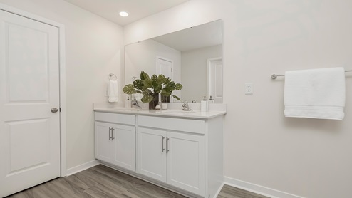 Primary bathroom with double vanity and glass door shower