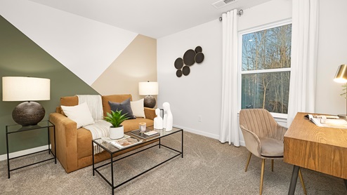 Carpeted bedroom with large window used as an office