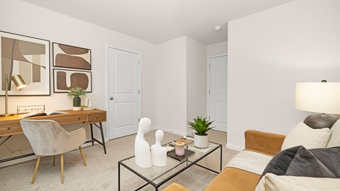 Carpeted bedroom with large window used as an office
