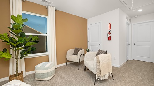 Open space carpeted loft area with large window