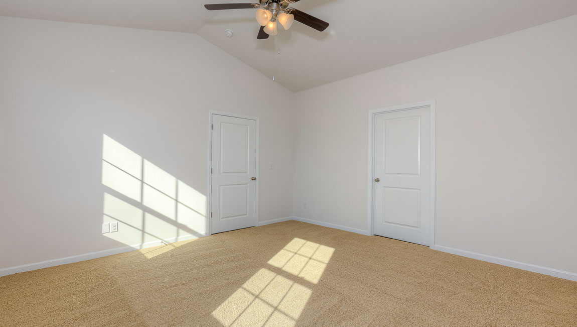 Primary carpeted bedroom with windows