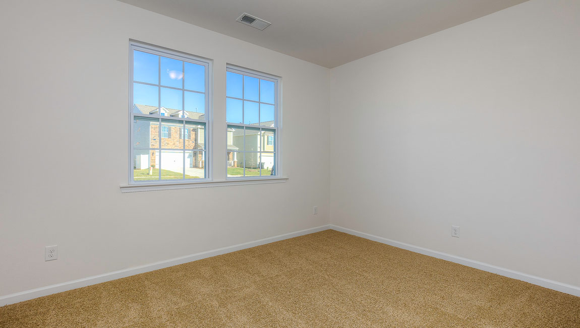 Carpeted bedroom with windows
