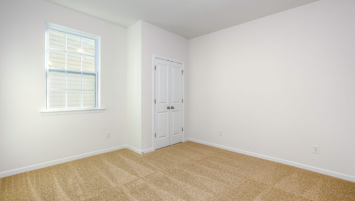 Carpeted bedroom with windows