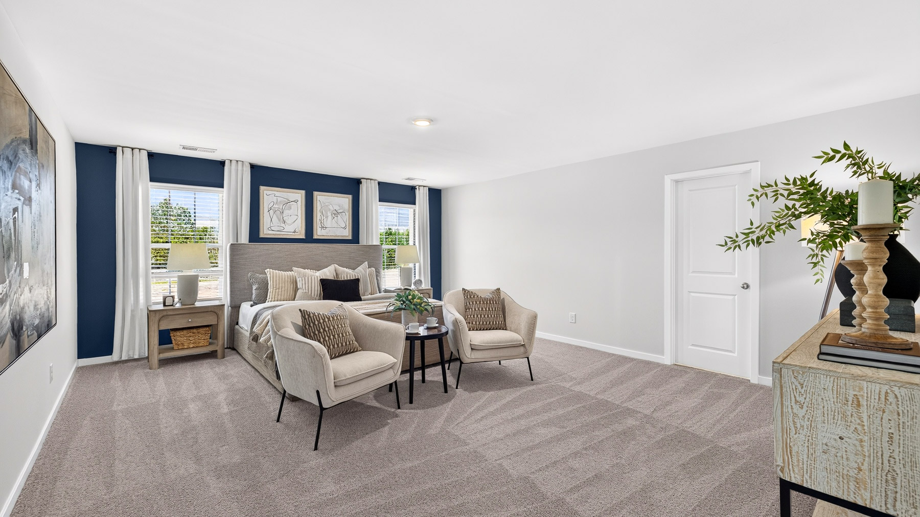 Primary carpeted bedroom with windows