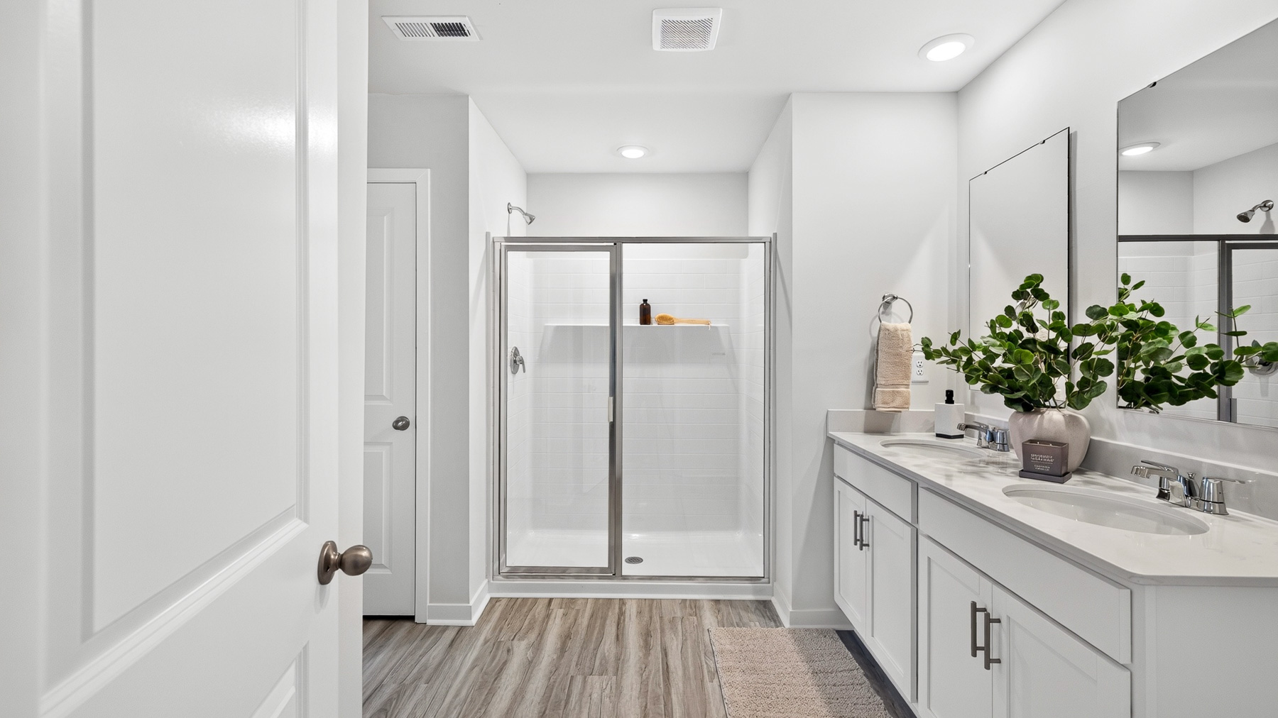 Primary bathroom with double sinks and standing glass shower and tub