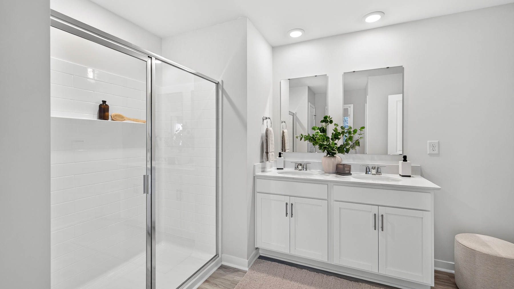 Primary bathroom with double sinks and standing glass shower and tub