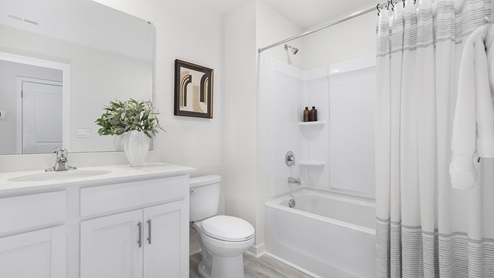 Bathroom with white cabinets and countertop and shower and bathtub combination