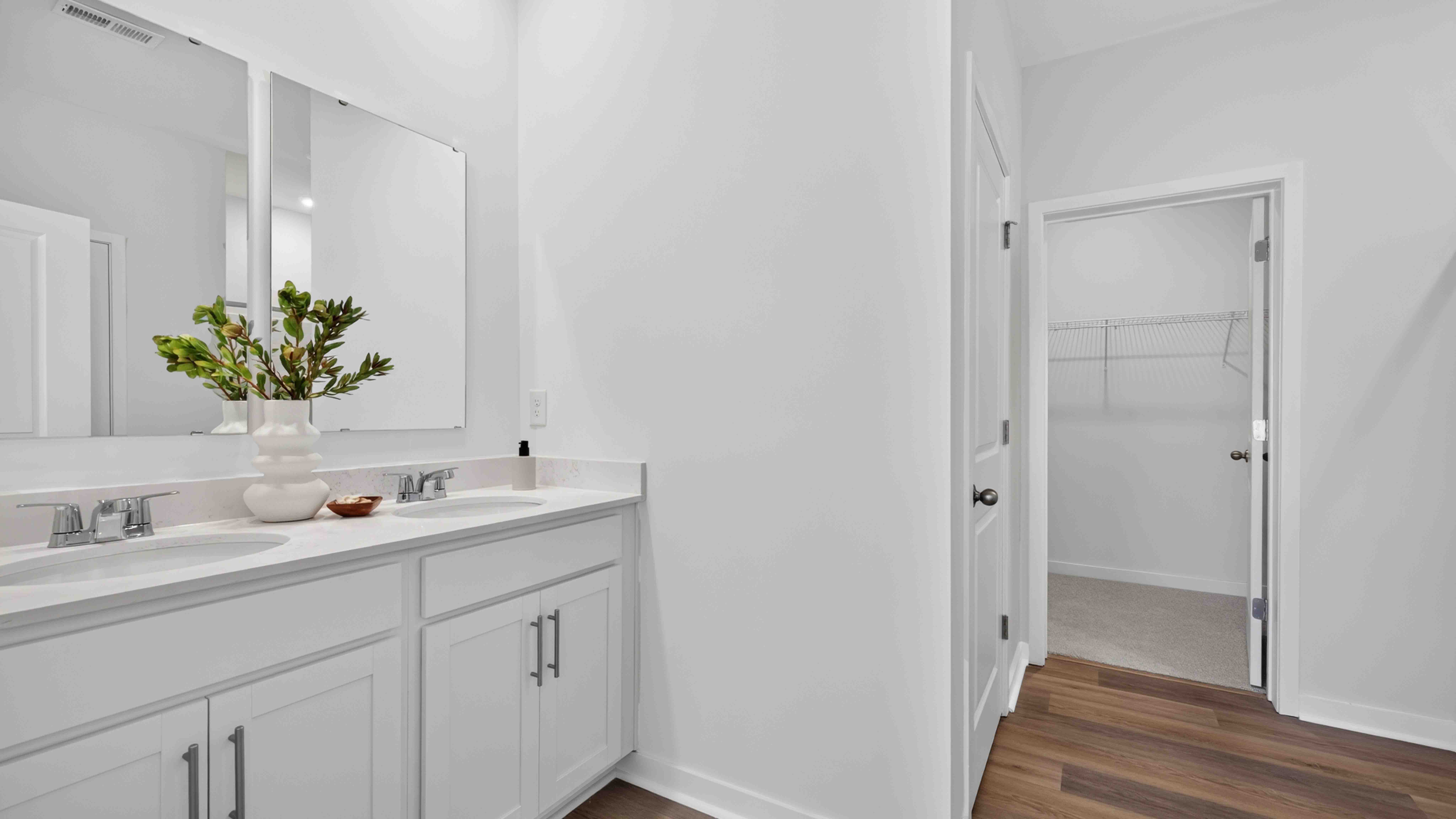 Primary bathroom with double sinks, standing glass shower, and toilet