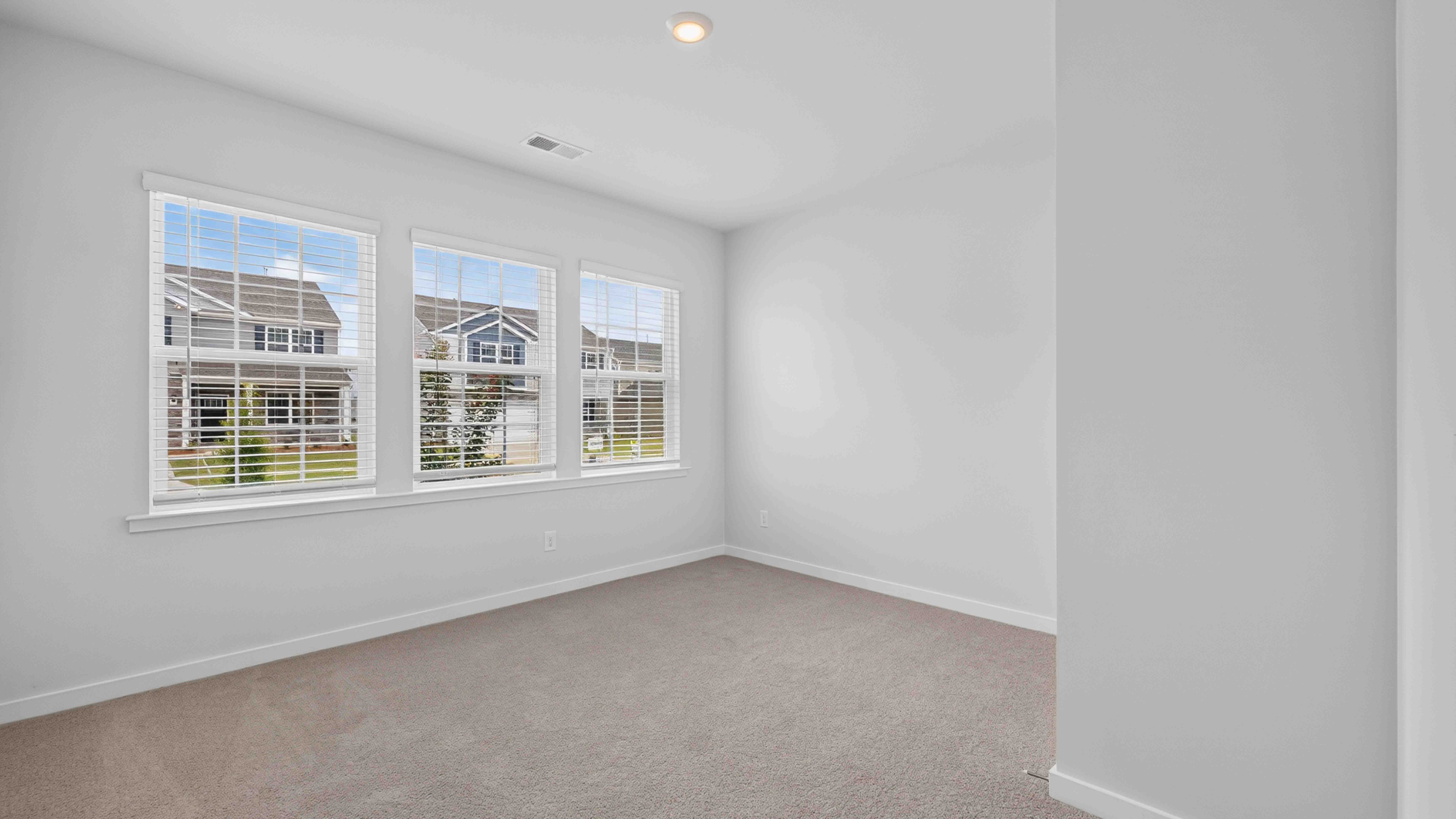 Carpeted bedroom with windows
