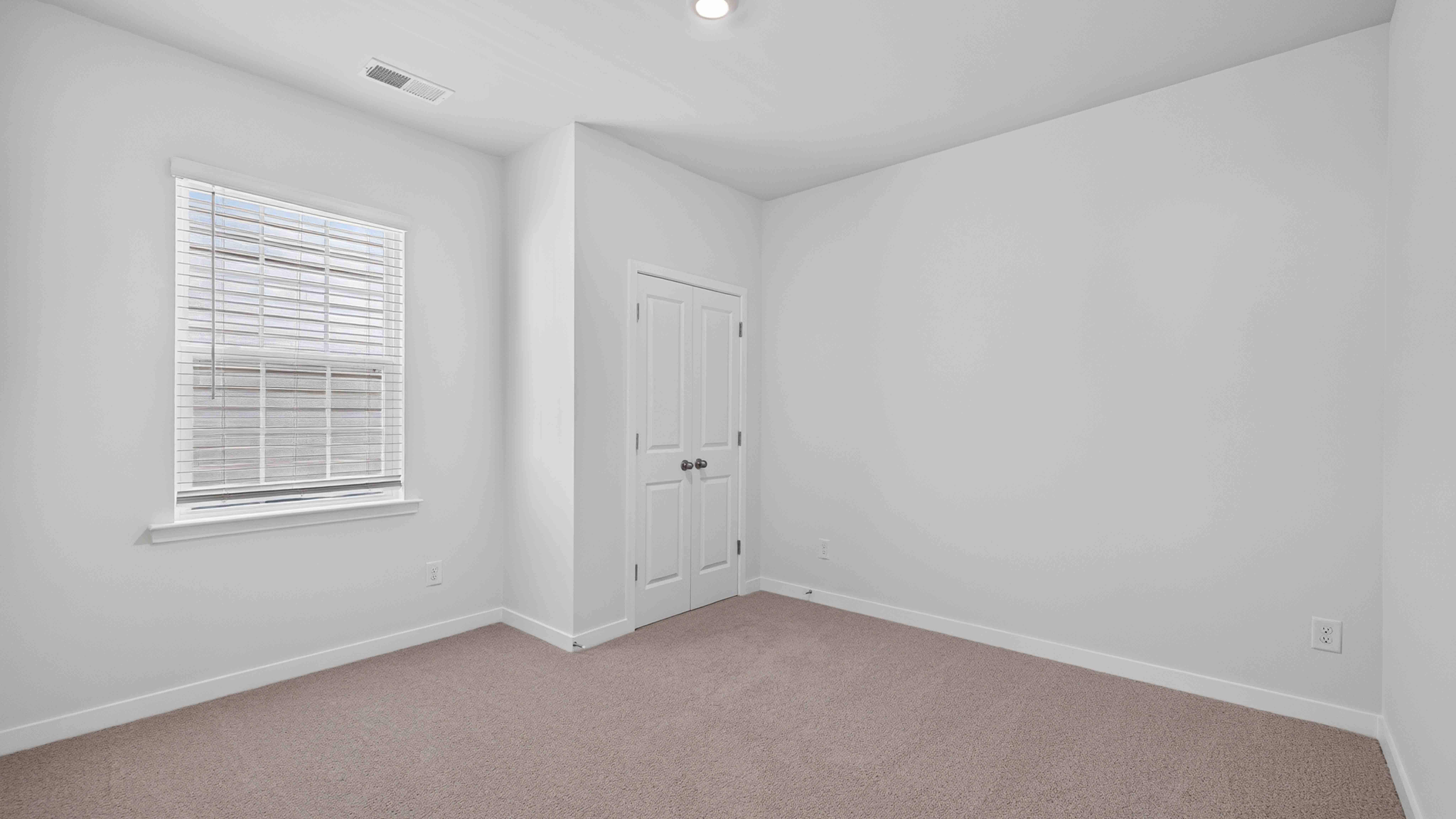 Carpeted bedroom with windows