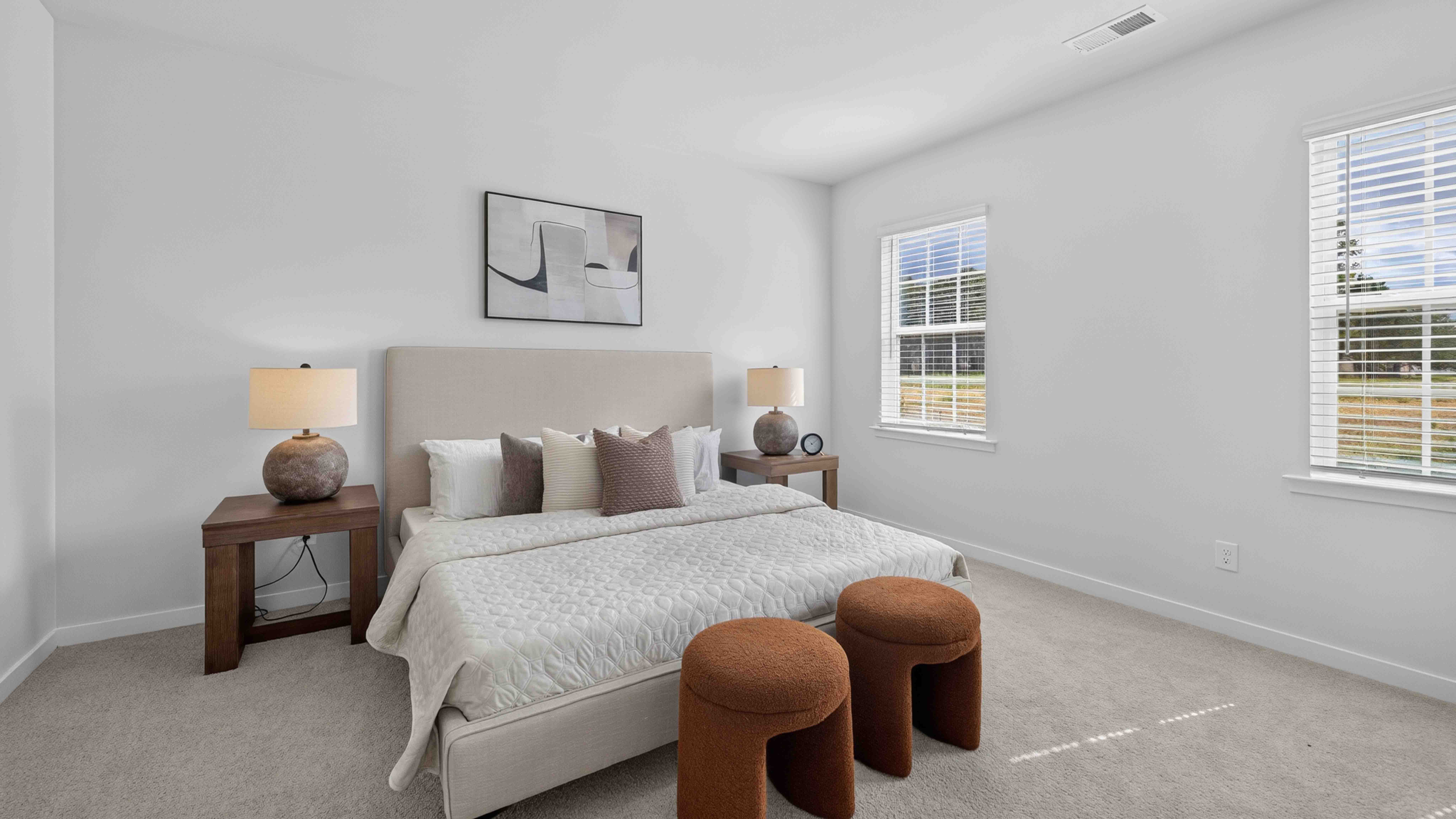 Primary carpeted bedroom with windows