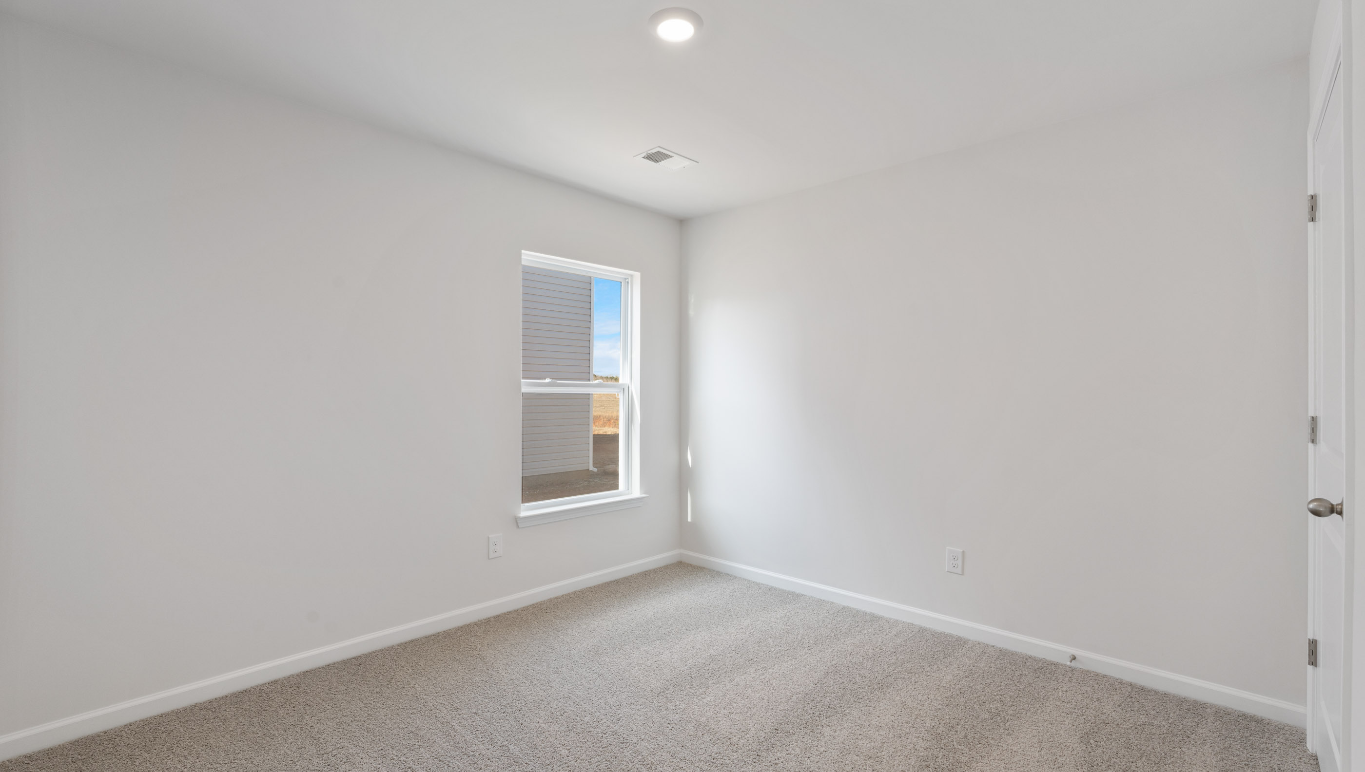 Bedroom with carpet and window.