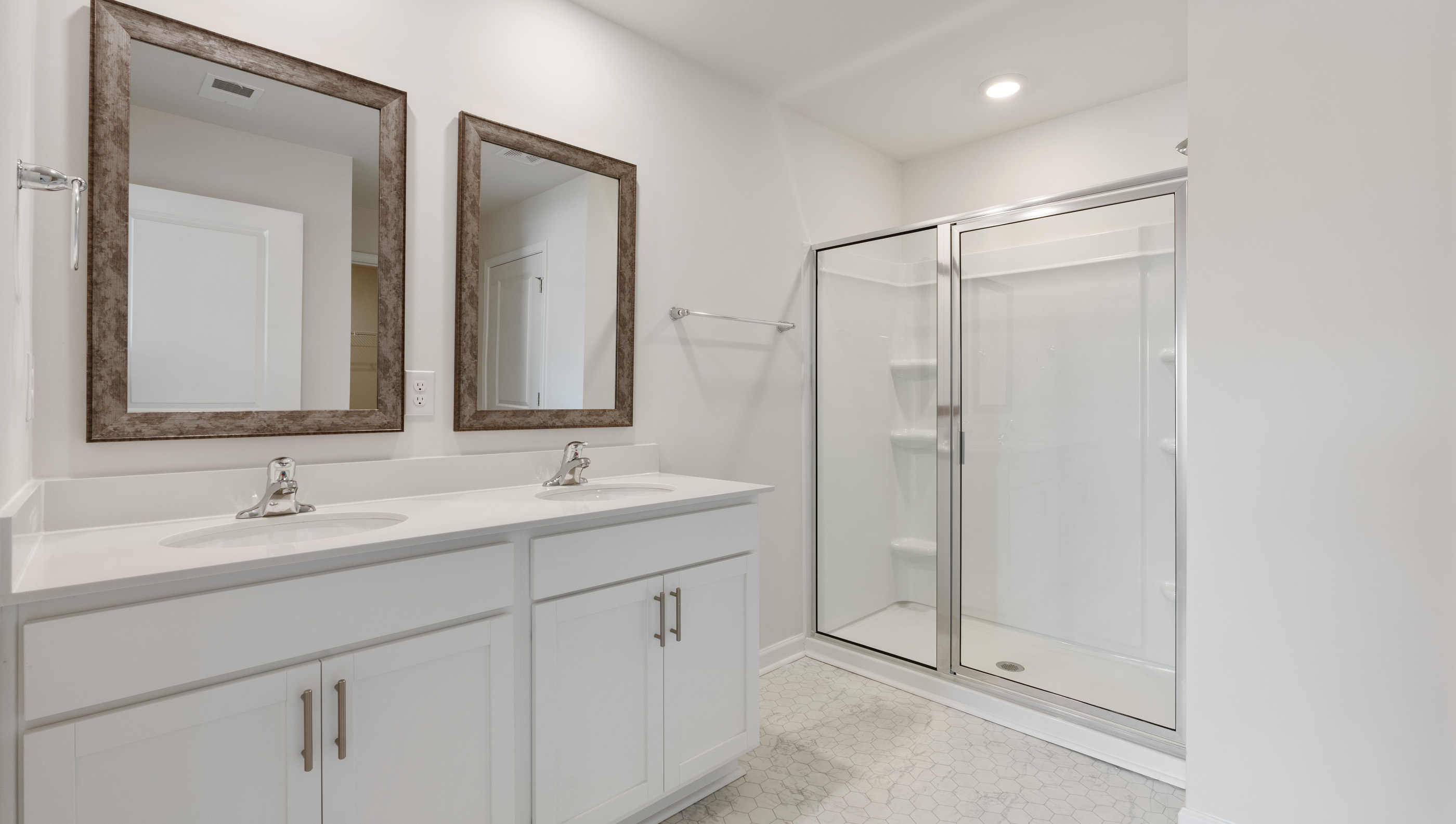 Bathroom with dual vanity and walk in shower.