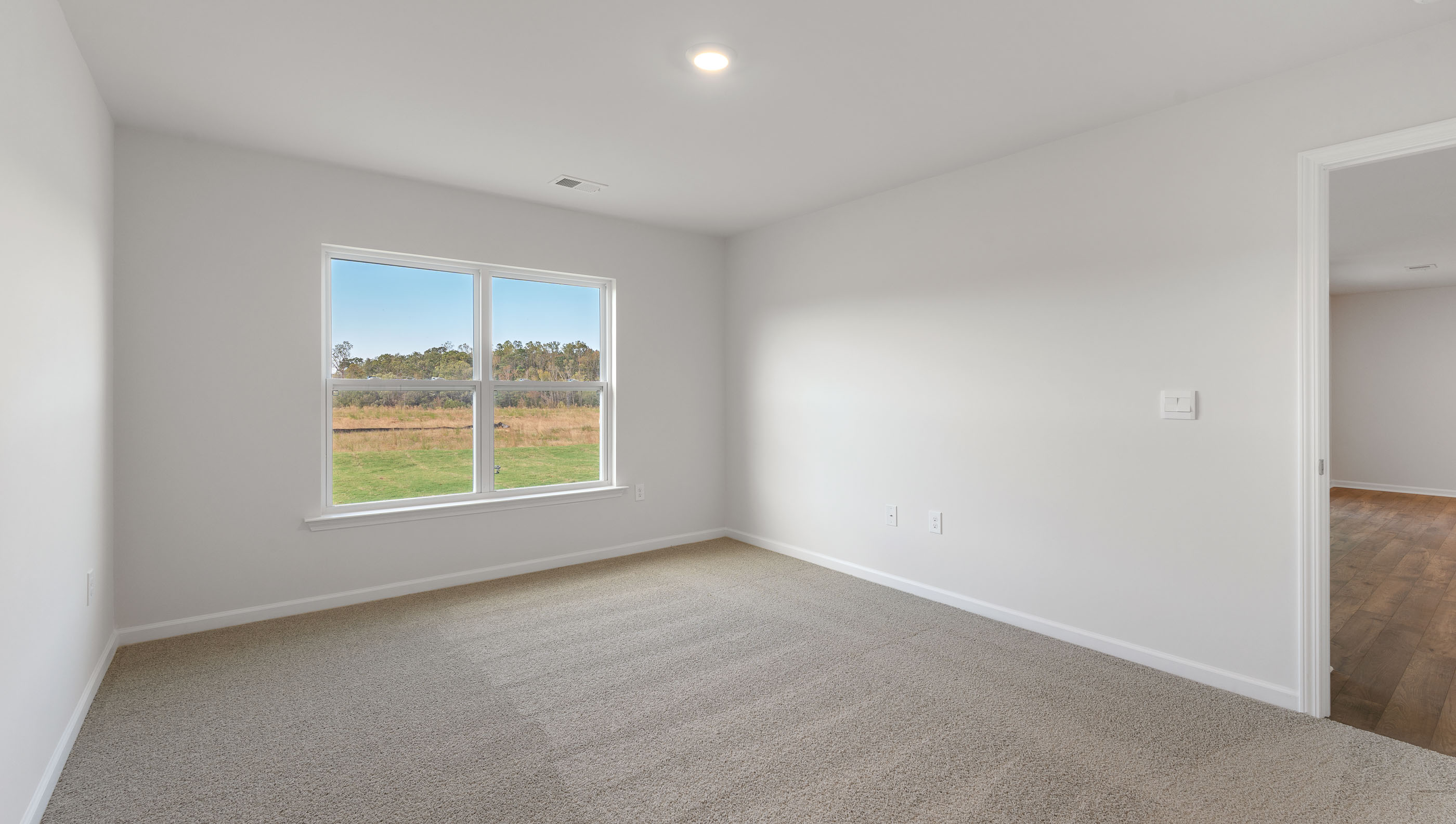 Bedroom with carpet and windows.