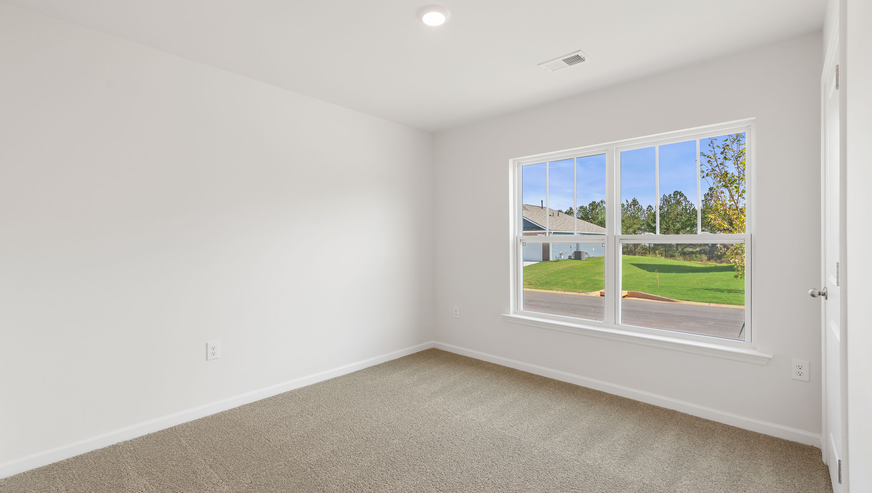 Bedroom with carpet and windows.