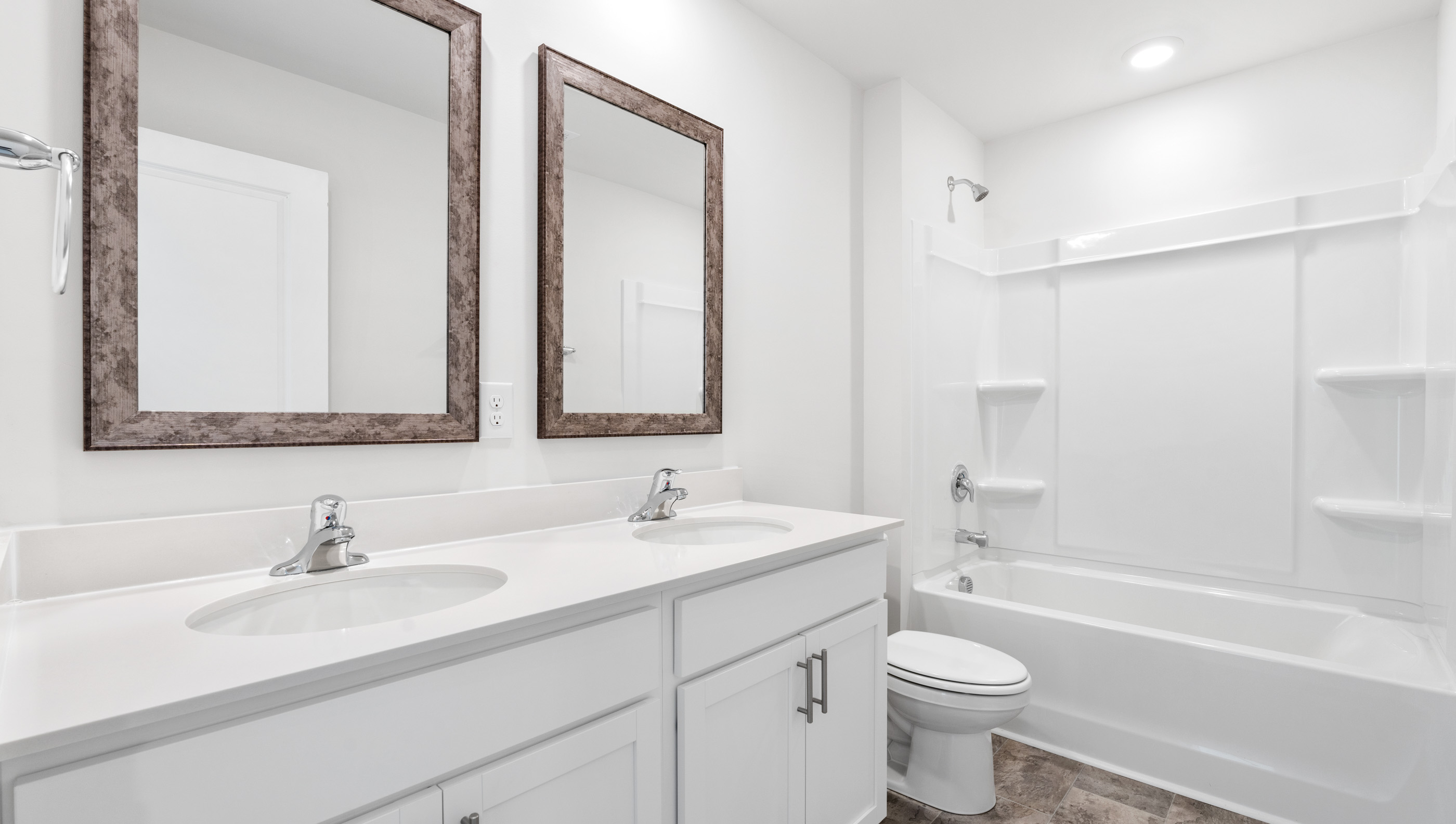 Bathroom with dual vanity and tub.