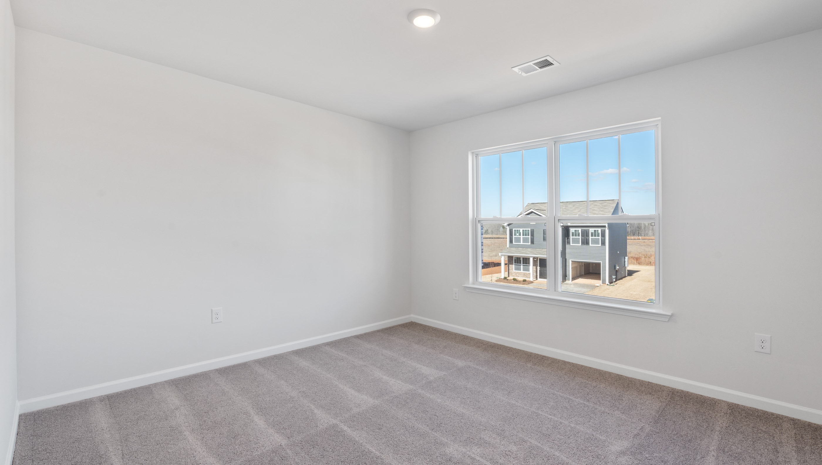 Bedroom with carpet and windows.